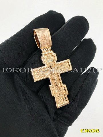 Крупный золотой православный крест на ладони